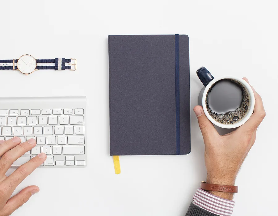 Escritorio con libreta, café y teclado, representando estrategia de contenido